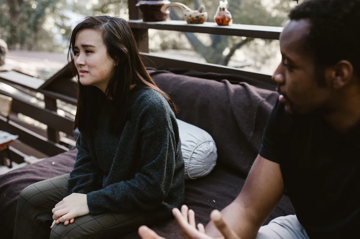 Two people having an honest conversation on an outdoor bench
