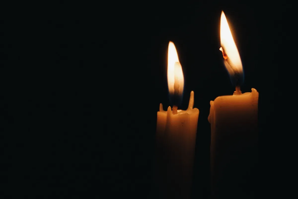 Two candle flames burning steadily against the dark